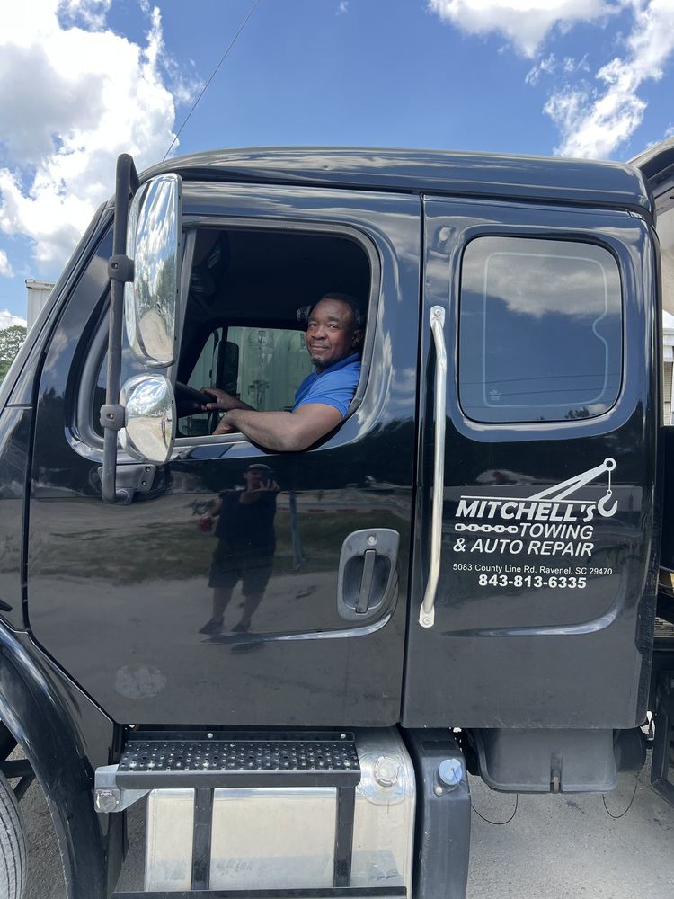 Owner Trevor Mitchell in his Mitchell's Towing wrecker in Ravenel, SC, address and phone on the door